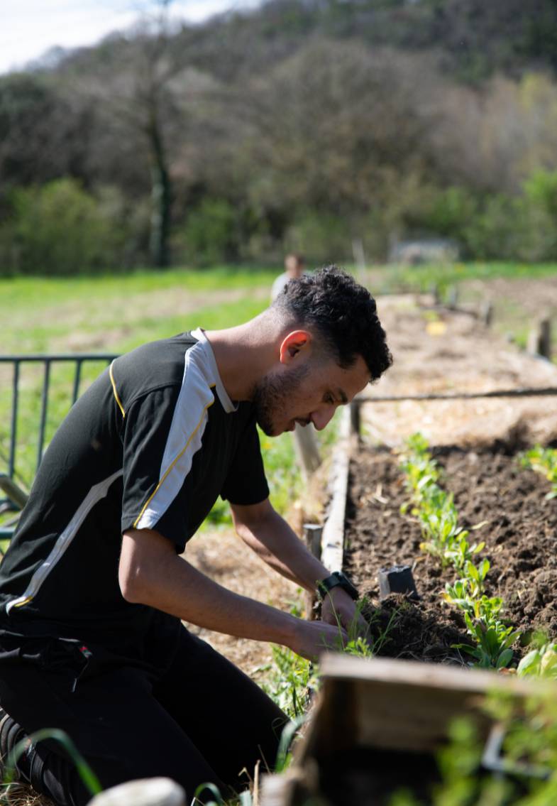 Jeune volontaire au jardin pour aider les porteurs de handicap du foyer de vie Le Béal à Taulignan
